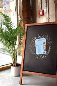 Aufsteller mit dem Flyer für die Einweihung und "Herzlich Willkommen"-Schriftzug